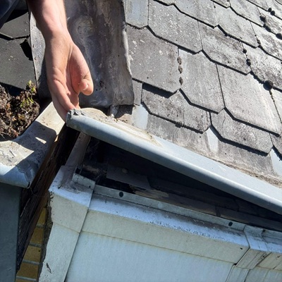 Réparation de fuite sur corniche en zinc et vérification de l'étanchéité de la toiture en ardoises. Service de dépannage rapide par Protec Toiture.